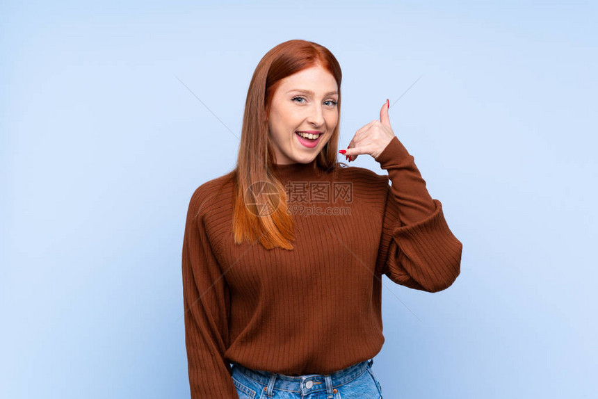 年轻红发女红发女青年在孤立的蓝背景图片