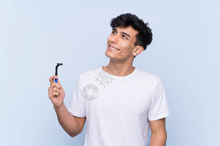男人在孤立的白种背景上刮胡子一边图片