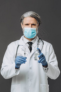 穿着白大衣手套和面具准备注射疫苗的灰色长发医生图片