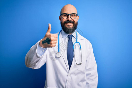 长胡子戴眼镜和听诊器的秃头大夫在蓝色背景下用手举起手来图片