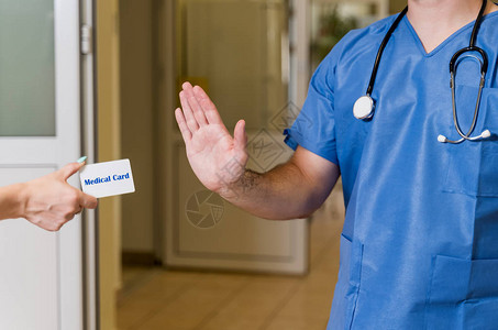 中年白人男医生用听诊器拒绝医疗卡背景模背景图片