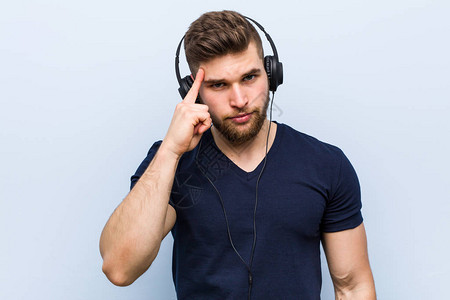 年轻的caucasian男子听音乐图片
