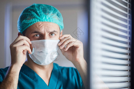 男外科医生在办公室站着时身戴保护面罩的医图片