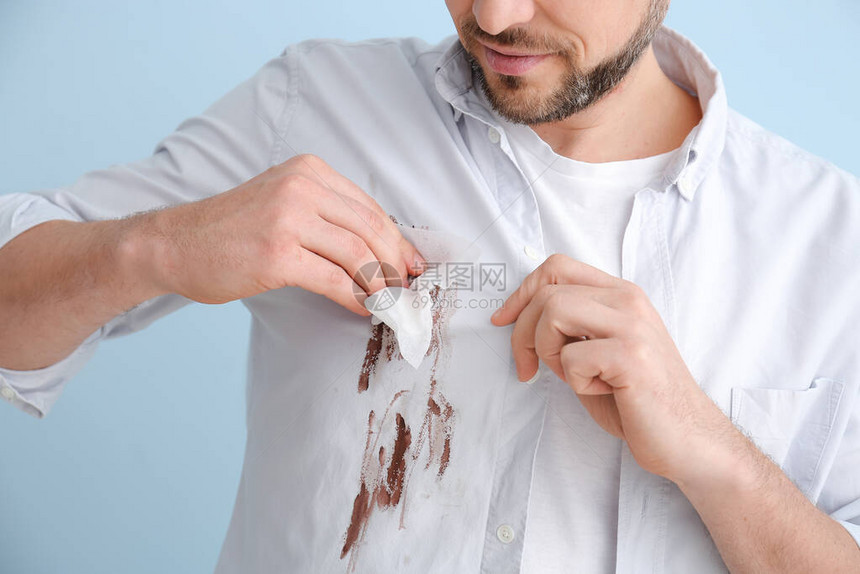 男人用彩色背景擦衣服上的污垢图片
