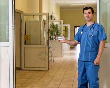 中年白人身穿蓝色衣服拿着医疗卡的听诊器的男医生图片