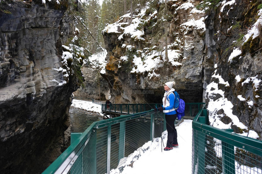 冬天在约翰斯顿峡谷徒步旅行的年轻女子加拿大落基山脉班夫公园艾伯图片