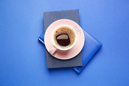 一杯热咖啡和彩色背景的书图片