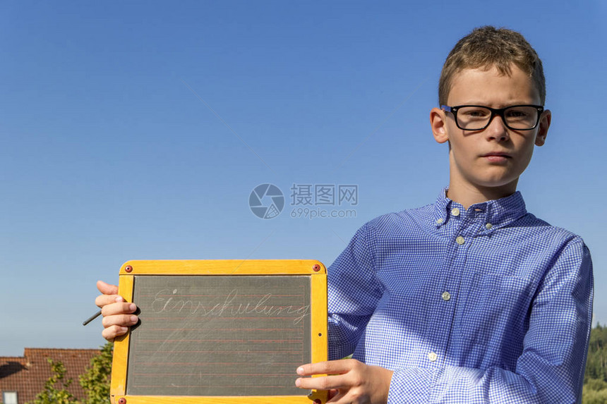 学校招生上戴眼镜和黑板的聪明男孩坚图片