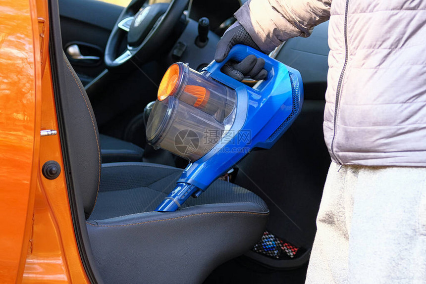用蓝色真空吸尘器清洁汽车内部图片