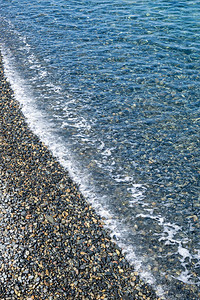 海浪冲向一个小石头海滩对图片