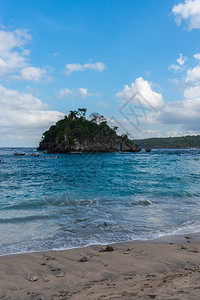 热带海滩海洋岩石和绿海蓝天空的景象图片