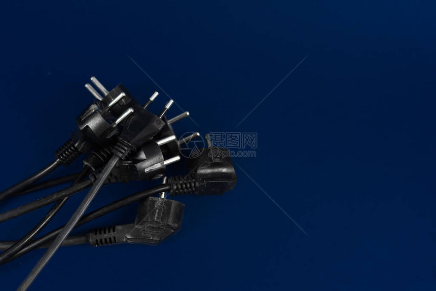 旧的用过的带插头的电线位于蓝色背景上图片