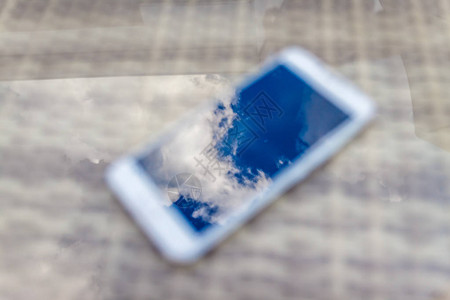 蓝天的反射与电话智能手机中的云团图片