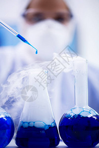 近距离的蓝色溶液从烟雾液体的试管中滴出保护设备科学家图片