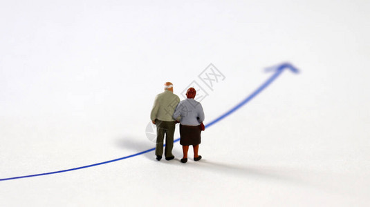 一对站在蓝色箭头上的微型老夫妇的背影关于增加老年人数量和延长退图片