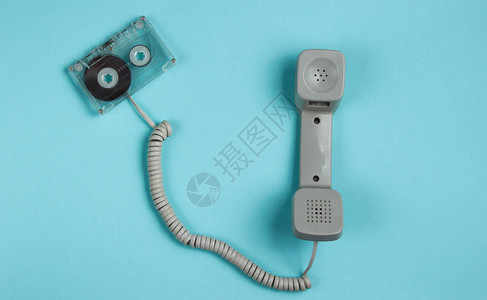 蓝纸背景上的电话听筒和录音磁带最小回溯静态生命图片
