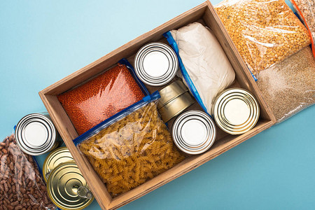 蓝色背景的木盒子食物捐赠概念图片