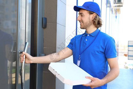 男快递员在入口处提供比萨饼送餐服务图片