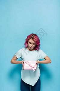穿着粉色头发拿着礼物盒和蓝底弓的红发背景图片
