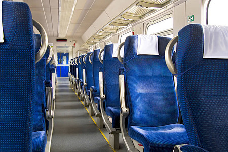 现代城际特快列车的内部在铁路运输中排成一排的宽大舒适座椅的后视图空荡的沙龙背景图片