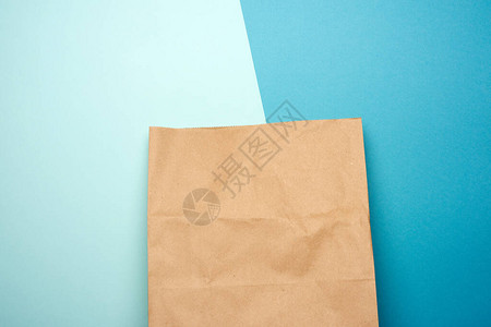 蓝色背景的棕色牛皮纸一次纸袋图片