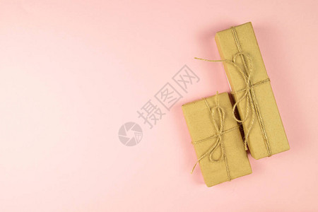 两盒装有手工艺纸的礼物盒和粉红色背景的薄饼丝带最图片