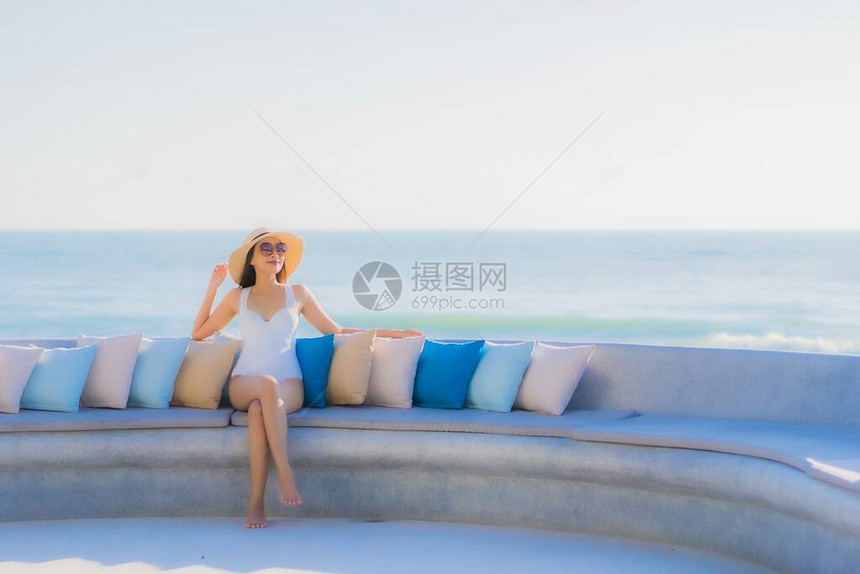 肖像美丽的亚洲年轻女在海滩和蓝天周围开心地微笑图片