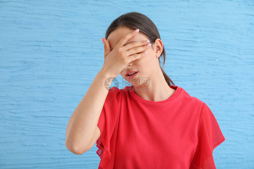 用彩色背景遮住眼睛的年轻女子图片