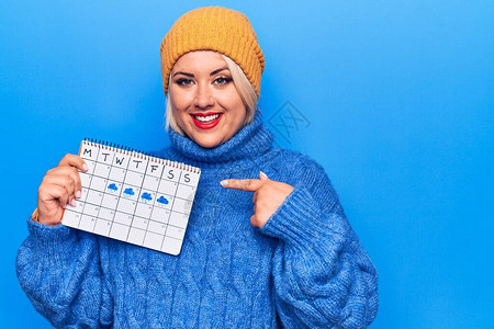 漂亮的大号女人拿着天气日历图片