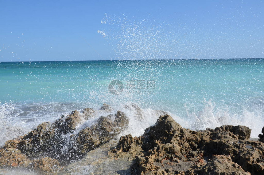 蓝色海洋水喷洒在海岸图片