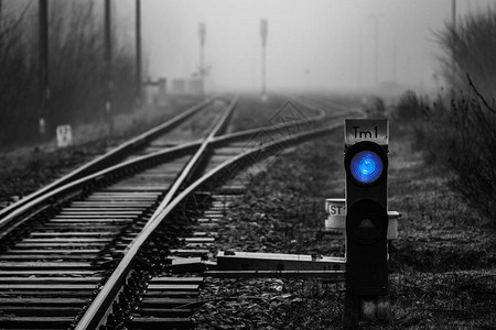 铁路交界处消失在雾中的蓝光铁路信号背景图片