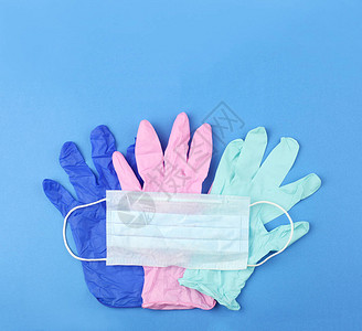 用于或冠状防护的个人设备医用口罩和彩色手套蓝色背景上图片