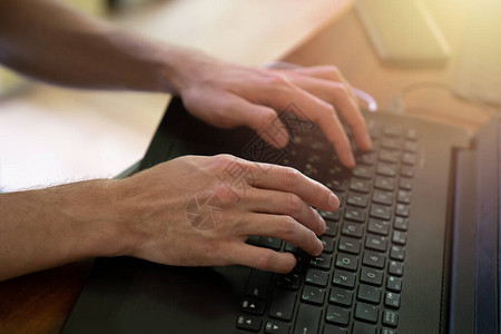 在黑色电脑键盘上打字的人手图片