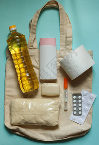 蓝色背景中白色绳袋中的橄榄油麦片基本必需品和个人卫生用品图片