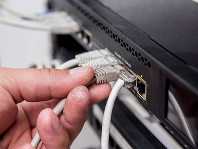 连接网络电缆和开关的技术员图片