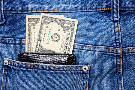 黑色皮夹和钱在背后蓝色牛仔裤口袋的黑皮图片