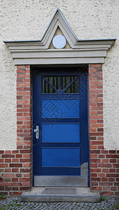 砖房入口的蓝色装甲门图片