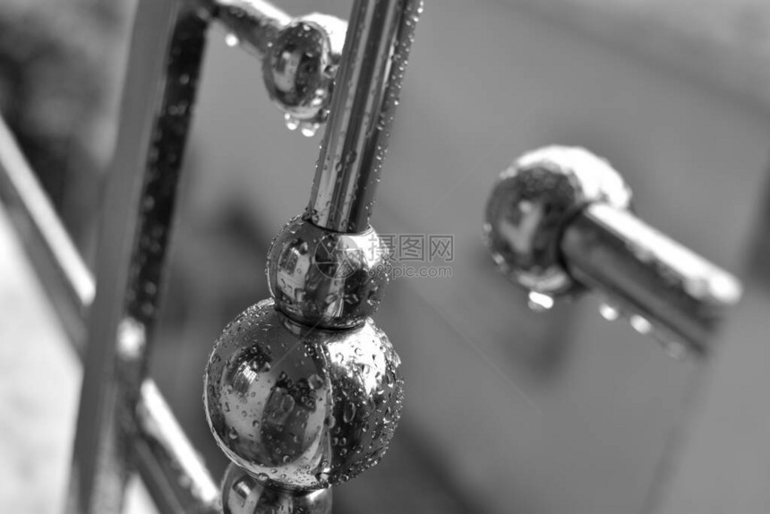 雨天从金属棒滴下的水滴落而来黑白抽象的钢铁栏杆图画图片