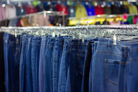 衣物店商的吊架上有许多不同的蓝色牛仔裤软选择聚焦摄影图片