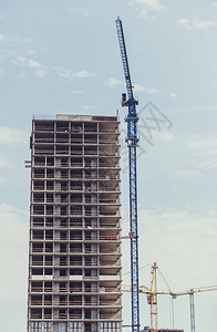 三台建筑起重机在一座正在建设的多层建筑的背景下新房图片
