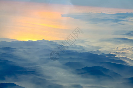 高山的烟雾中太阳束照耀着从飞机窗图片