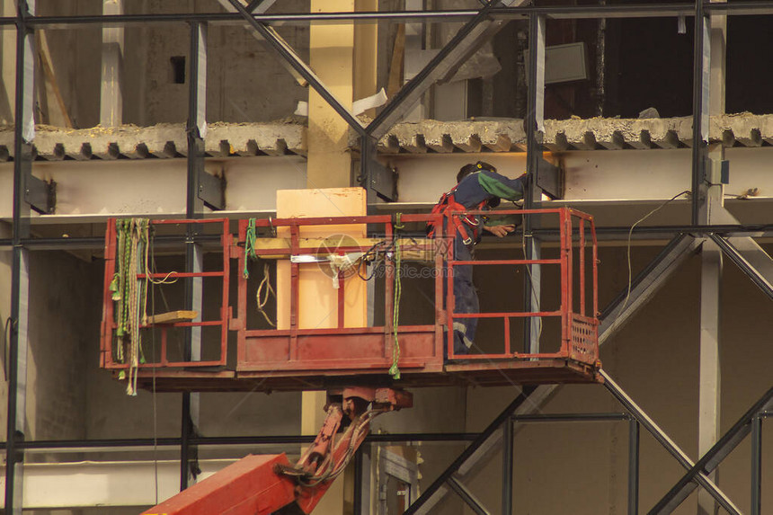利用电焊接汽车电梯起吊工人远升机维修大楼外墙图片