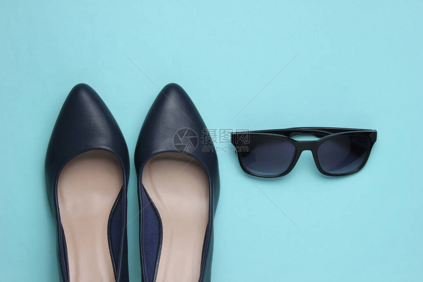 时髦的女外观蓝色背景的皮鞋高图片