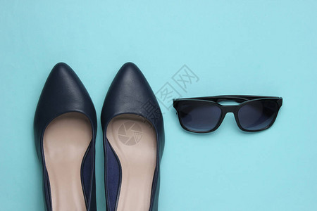 时髦的女外观蓝色背景的皮鞋高图片