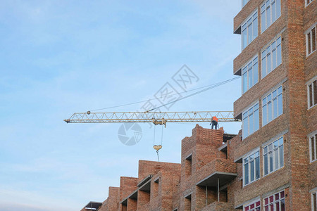 未完成多层砖房的建造高空起重机和建筑工碎图片