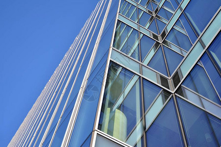 现代办公建筑墙由蓝色天空的背景图片