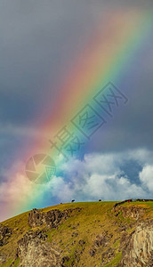 山上的彩虹与马和石墙图片