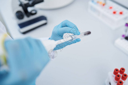 身着无菌手套将血液滴入试管并在实验室进行血液测试的无法辨认的实验室研图片