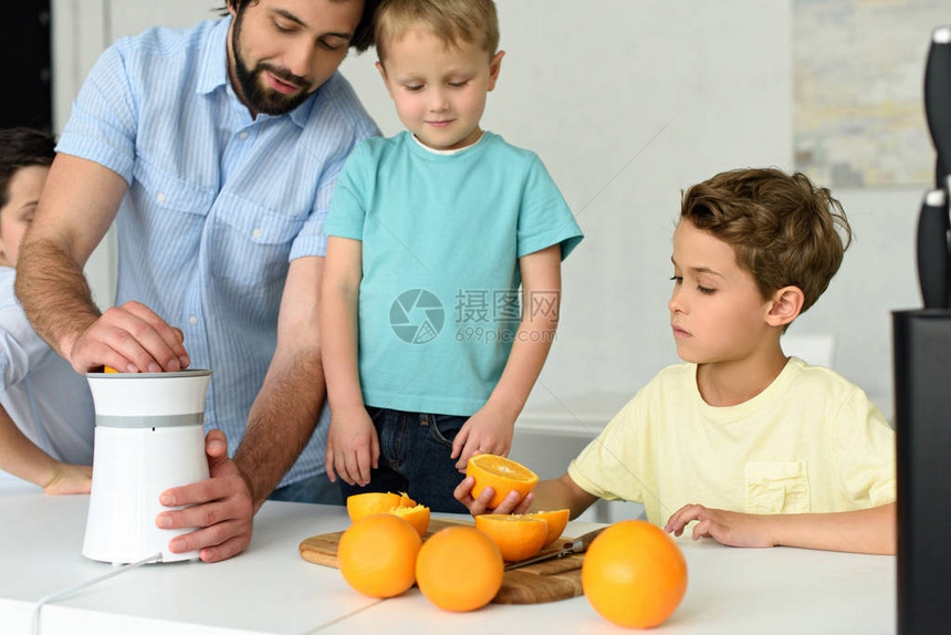 家庭在家中厨房一起做新鲜橙汁的局图片
