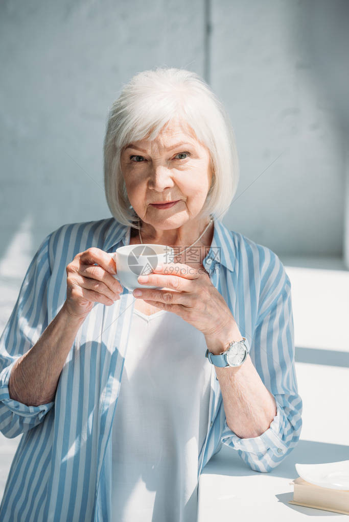 灰色头发女肖像与咖啡杯站在图片